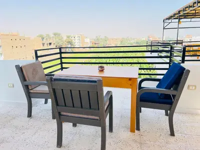 a table and chairs on top of a roof at Villa Pure Luxor in Luxor
