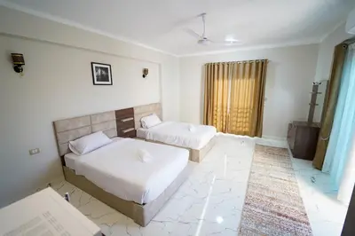 a bedroom with two beds and a window at Villa Pure Luxor in Luxor