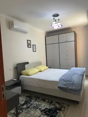 a bedroom with a bed with a large white cabinet at The view -Clubhouse in Hurghada
