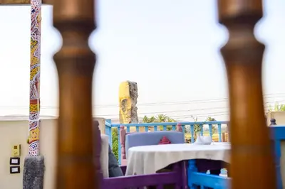 a table with a white table cloth on a balcony at Flamingo Memnon Guest House in Luxor