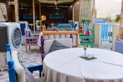 a table with a white table cloth on a room with chairs at Flamingo Memnon Guest House in Luxor