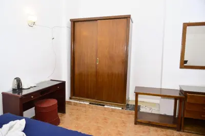 a room with a bed and a wooden door and a desk at Flamingo Memnon Guest House in Luxor