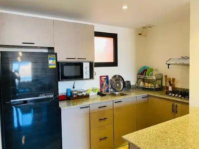 a kitchen with a black refrigerator and a counter at The Clubhouse Apartment in Hurghada