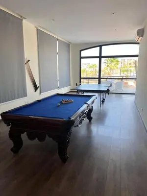two pool tables in a room with a large window at The Clubhouse Apartment in Hurghada