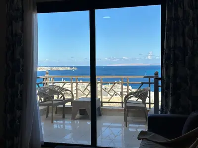a room with a view of the ocean from a balcony at The view -Nubian One bedroom in Hurghada