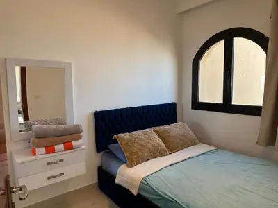 a bedroom with a blue bed and a mirror at The view -Nubian One bedroom in Hurghada