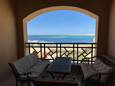 a room with a balcony with a view of the ocean at The Nubian Sea View in Hurghada