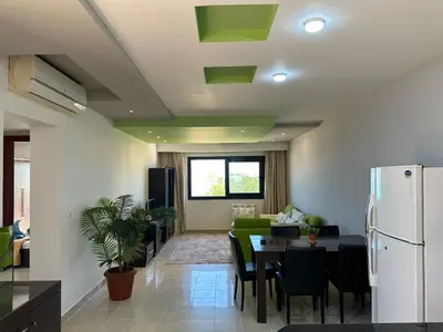 a kitchen and living room with a table and a refrigerator at The Nubian Seabreeze in Hurghada