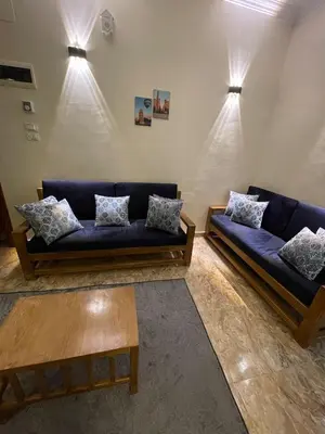 a living room with two blue couches and a table at Luxe Nest Luxor Serviced Apartments 102 in Luxor