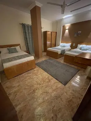 a hotel room with two beds and two rugs at Luxe Nest Luxor Serviced Apartments 102 in Luxor