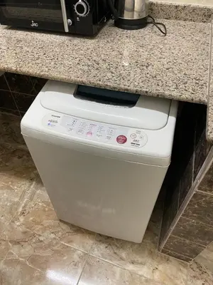 a white washer and dryer under a kitchen counter at Luxe Nest Luxor Serviced Apartments 102 in Luxor