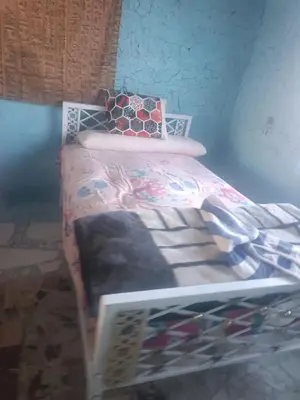 a small bed in a room with a bed frame at Isis farm house in Al Aqālitah