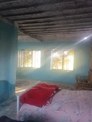 a bedroom with a bed in a room with windows at Isis farm house in Al Aqālitah
