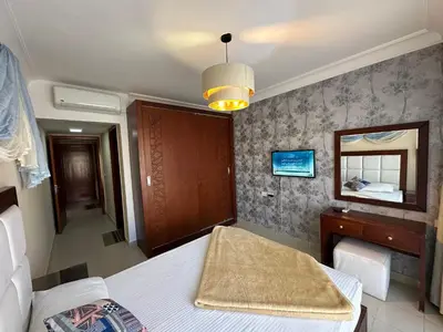 a bedroom with a bed and a mirror and a table at The Nubian Two-Bedroom Apartment in Hurghada
