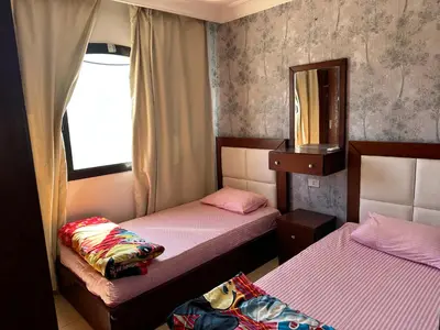 two beds in a small room with a mirror at The Nubian Two-Bedroom Apartment in Hurghada