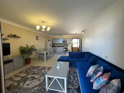 a living room with a blue couch and a table at The Nubian Two-Bedroom Apartment in Hurghada