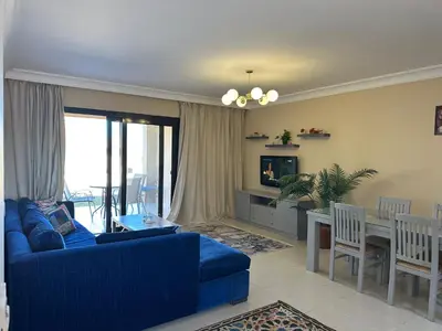 a living room with a blue couch and a table at The Nubian Two-Bedroom Apartment in Hurghada