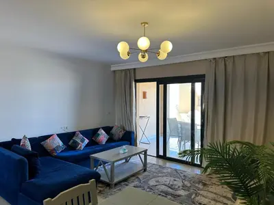 a living room with a blue couch and a table at The Nubian Two-Bedroom Apartment in Hurghada