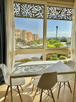 a dining room with a table and chairs and a window at One bedroom Mangroovy El Gouna in Hurghada