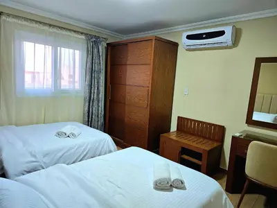 a hotel room with two beds and a mirror at Elnahla Villa in Hurghada