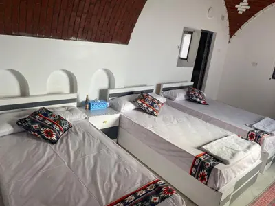 two twin beds in a room with at Maleka nubian guest house in Jazīrat Suhayl