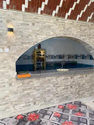 a stone fireplace with an arch in a room at Maleka nubian guest house in Jazīrat Suhayl