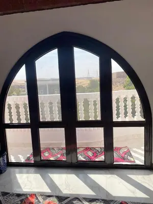 an arched window with a view of a balcony at Maleka nubian guest house in Jazīrat Suhayl