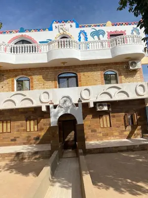 a brick building with a balcony on top of it at Maleka nubian guest house in Jazīrat Suhayl