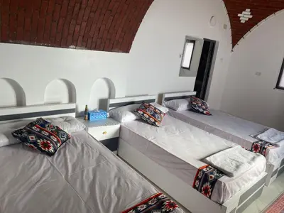 two twin beds in a room with two pillows at Maleka nubian guest house in Jazīrat Suhayl