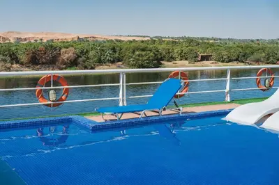 a blue chair sitting on the edge of a swimming pool at Savoy Yacht - Exclusive Nile Cruise from Luxor to Aswan in Luxor