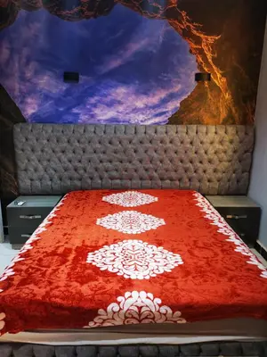 a bed with a red and white blanket on it at I&A studia in Hurghada