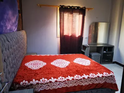 a bedroom with a red and white blanket on a bed at I&A studia in Hurghada