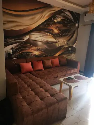 a couch in a living room with a painting on the wall at I&A studia in Hurghada