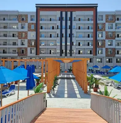 a large building with blue umbrellas in front of it at Sami and Sam studio apartment in Hurghada