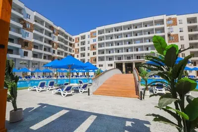 a resort with chairs and a pool and a building at Sami and Sam studio apartment in Hurghada