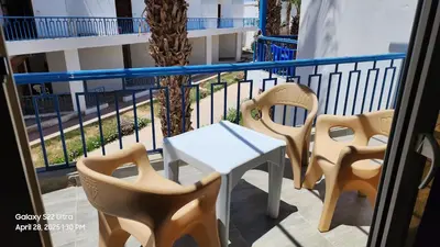 a balcony with chairs and a table on a balcony at Chalet - Mirage Bay Resort & Aqua Park in Hurghada