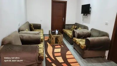 a living room with two couches and a tv at Chalet - Mirage Bay Resort & Aqua Park in Hurghada