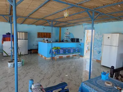 a large kitchen with blue walls and a refrigerator at Abo Orabi Guest House in Aswan