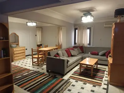 a living room with a couch and a table at fayrouz apartment in Jazīrat al ‘Awwāmīyah