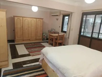 a bedroom with a bed and a desk and a table at fayrouz apartment in Jazīrat al ‘Awwāmīyah