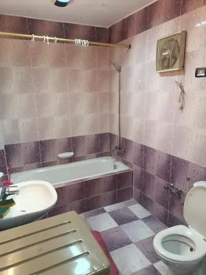 a bathroom with a toilet and a tub and a sink at fayrouz apartment in Jazīrat al ‘Awwāmīyah