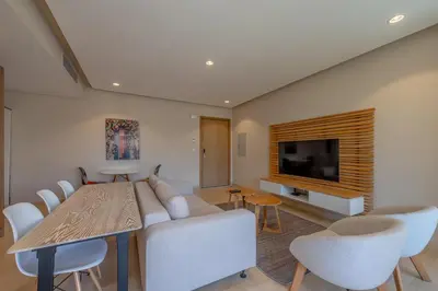 a living room with a couch and a table and a television at Cozy One Bedroom in Mangroovy in Hurghada