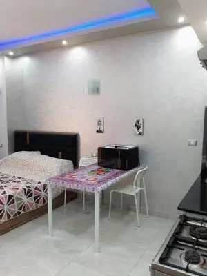 a bedroom with a bed and a table with a microwave at Compound El makramia 504 in Hurghada