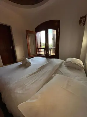 two white beds in a room with a window at El Gouna Sabina Y160 in Hurghada