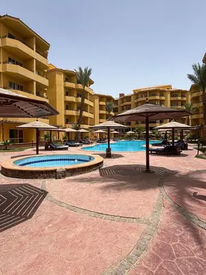a resort with a swimming pool with umbrellas at Stefy Holiday Hurghada in Hurghada