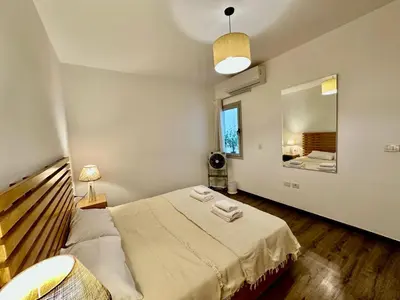 a bedroom with a large bed and a mirror at Cozy 2 bedroom Sholan 1 - Gouna in Hurghada
