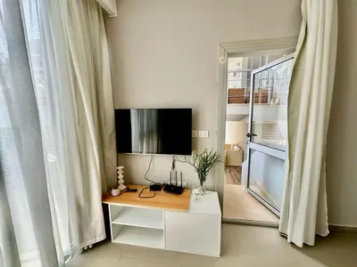 a living room with a tv and a desk with a television at Cozy 2 bedroom Sholan 1 - Gouna in Hurghada