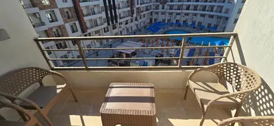a balcony with two chairs and a swimming pool at Tiba Golden Resort Hurghada in Hurghada