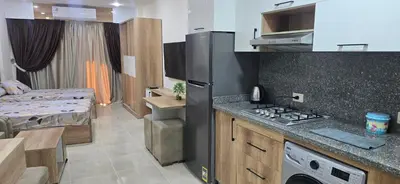 a kitchen with a stove and a bed in a room at Tiba Golden Resort Hurghada in Hurghada