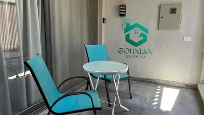 two chairs and a table in front of a sign at Cozy studio in Bali in Hurghada
